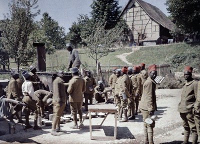 Een groep Senegalese soldaten in dienst van het Franse leger als infanteristen lunchen in Saint-Ulrich, Departement Haut-Rhin, Elzas, Frankrijk, 16 juni 1917 door Paul Castelnau